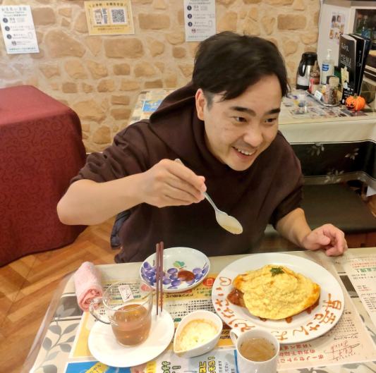 交流お食事会で、笑顔でオムライスを楽しむ春風亭昇吾師匠